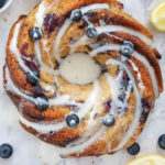 Lemon Blueberry Bundt Cake garnished with glaze, blueberries and lemon.