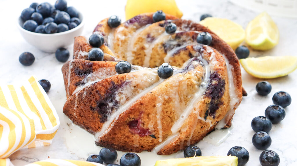 Lemon Blueberry Bundt Cake garnished with glaze, blueberries and lemon.