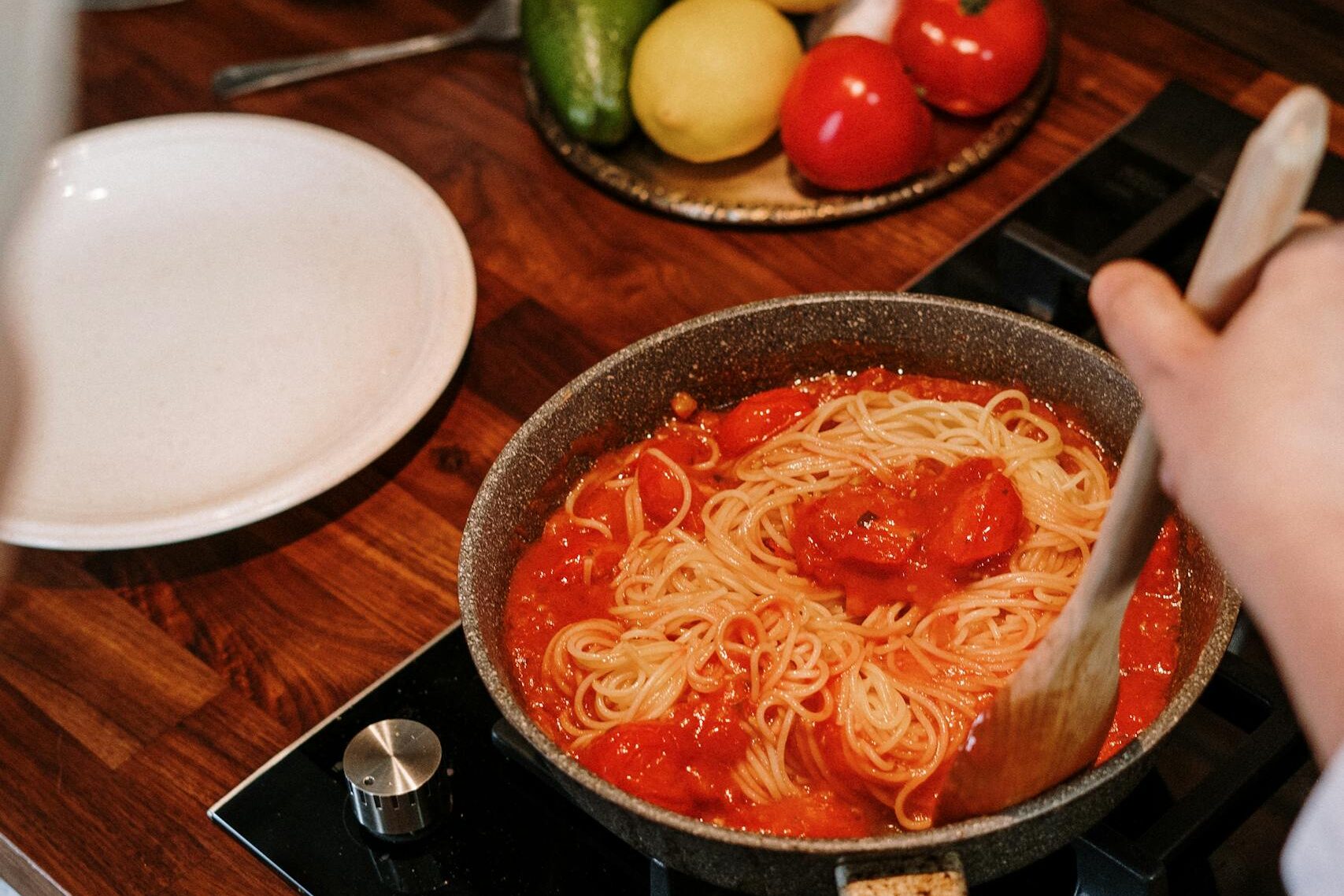 Cooking spaghetti with tomato sauce, showcasing the simplicity of how to make dinner when you'd rather just order takeout.