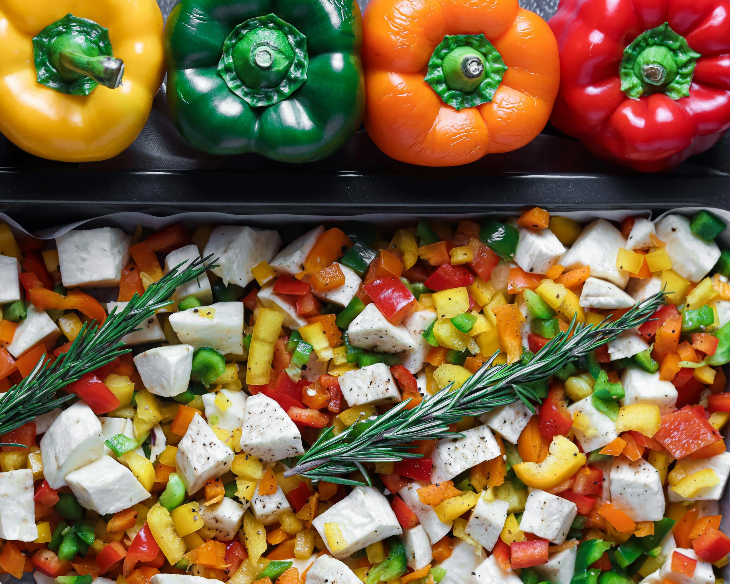Top view of a colorful assortment of bell peppers, diced vegetables, and feta cheese, perfect for healthy eating concepts.