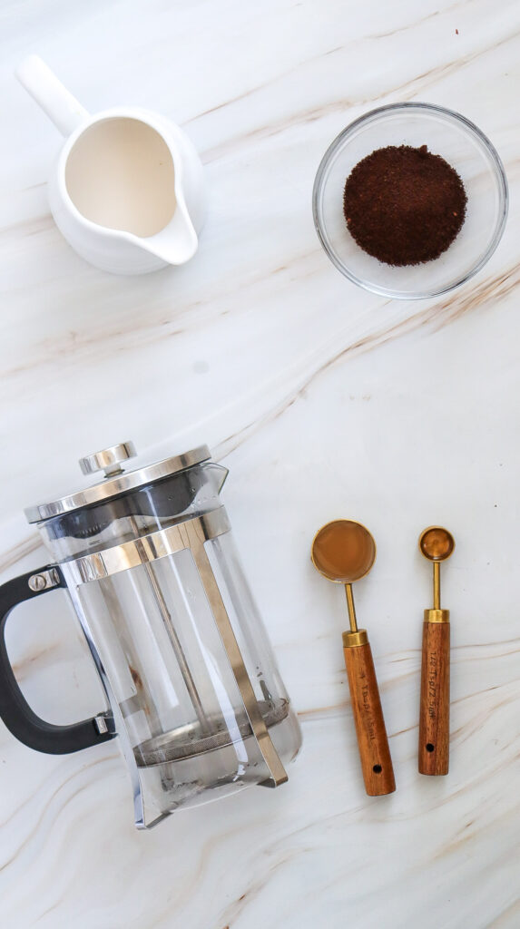 Ingredients and tools needed to make caramel iced coffee.